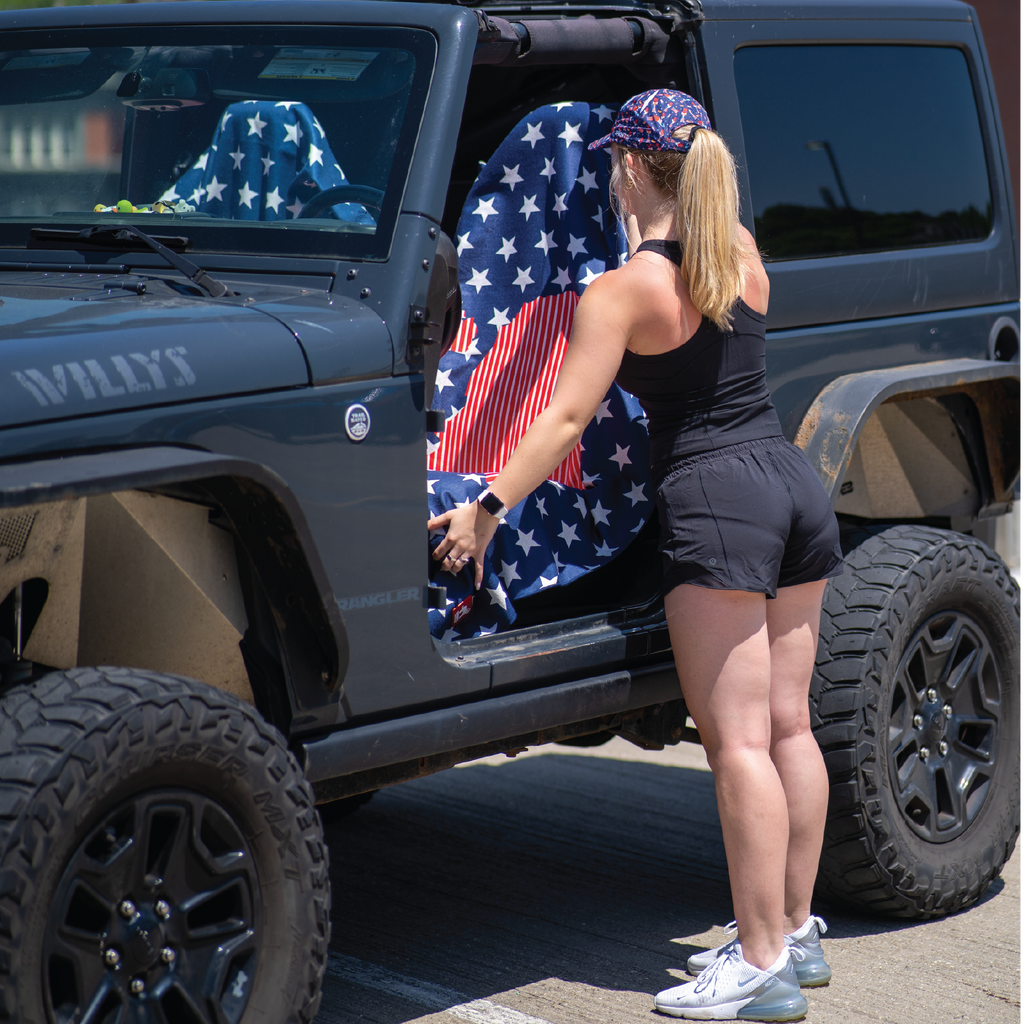 Woman putting towel on car seat with towel showing united states map against repeating pattern of stars, red white and blue colors