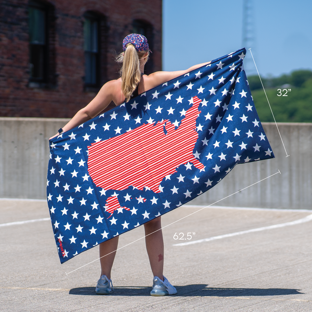 Woman spreading out towel showing united states map against repeating pattern of stars, red white and blue colors
