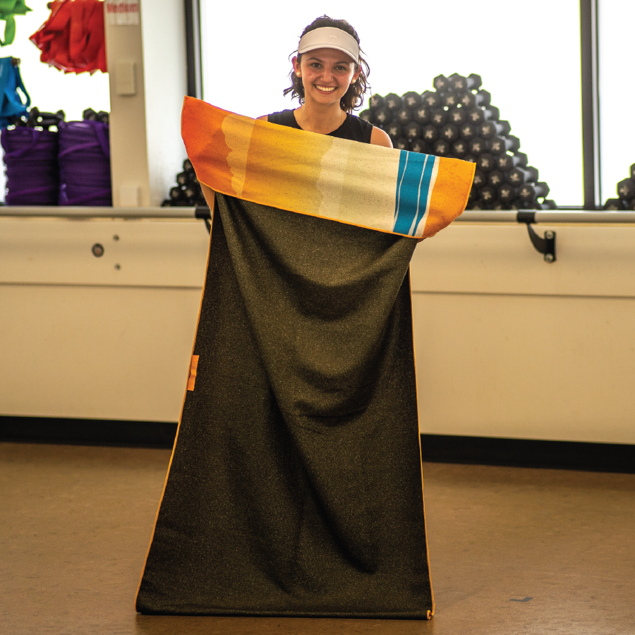 Woman showing pocket on back of towel.
