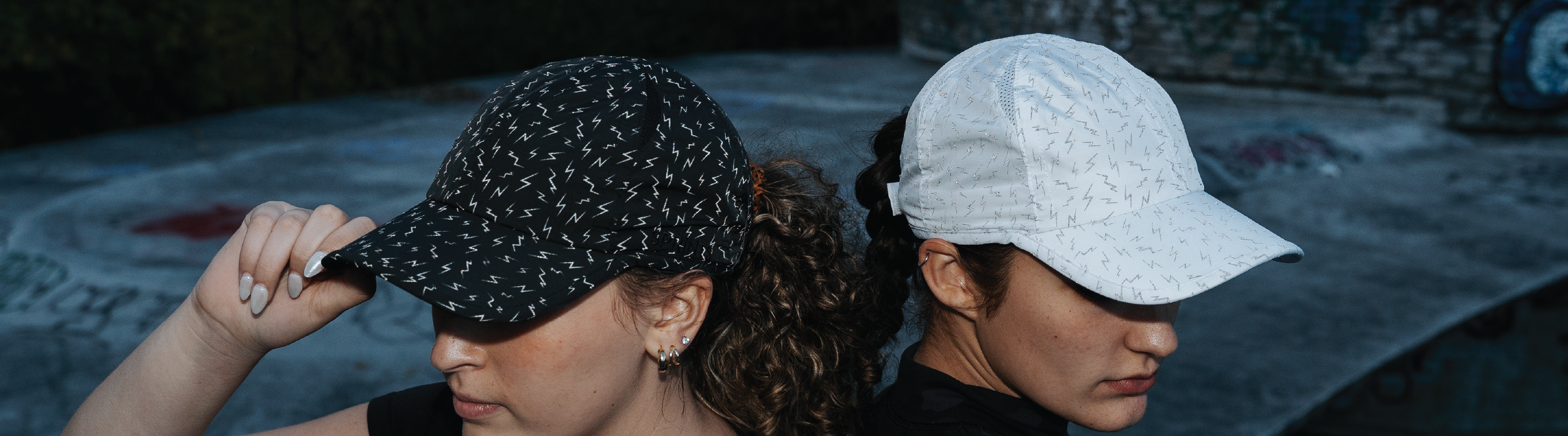 2 girls sitting back to back in hats with lightning bolts on them