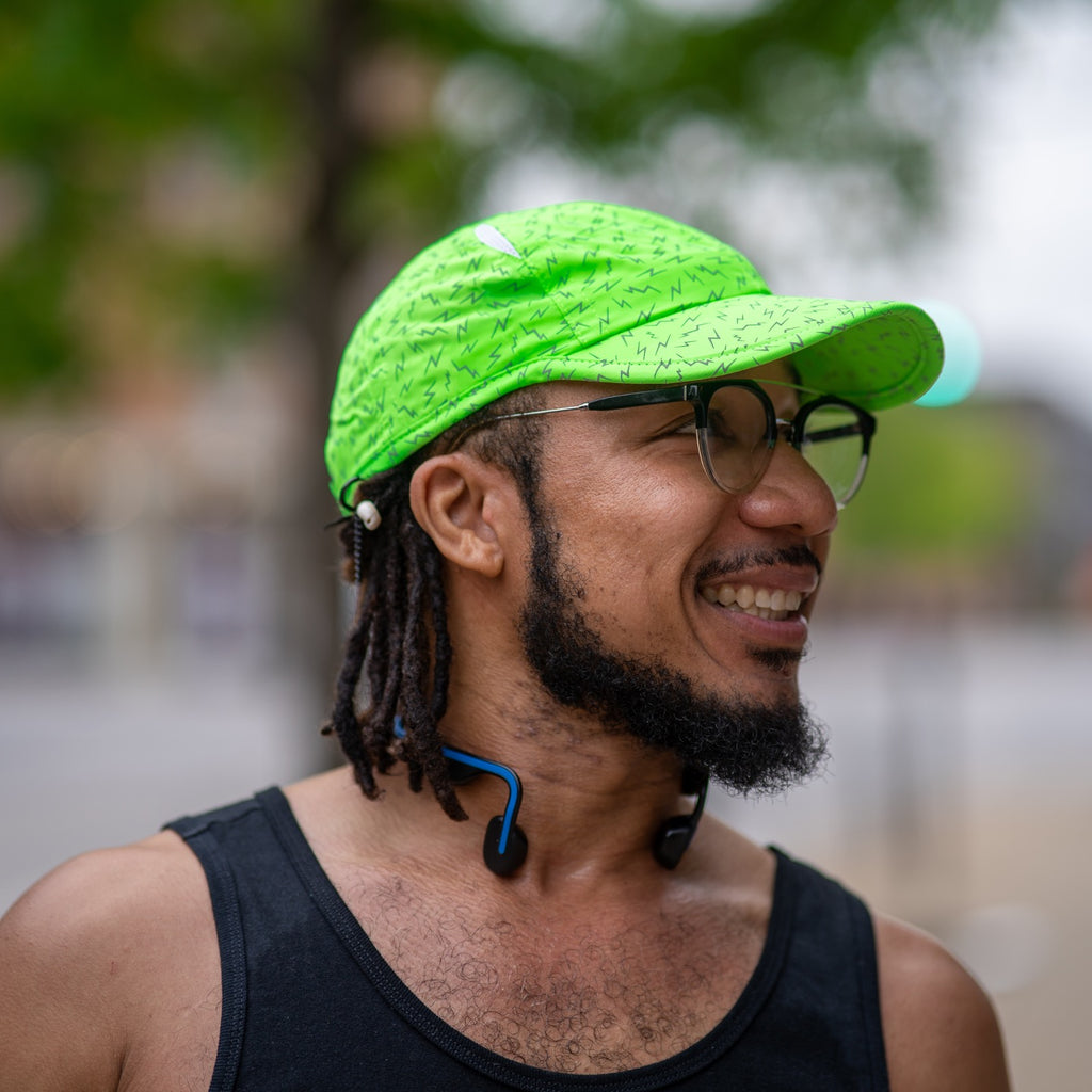 man wearing neon green hat with lightning bolts