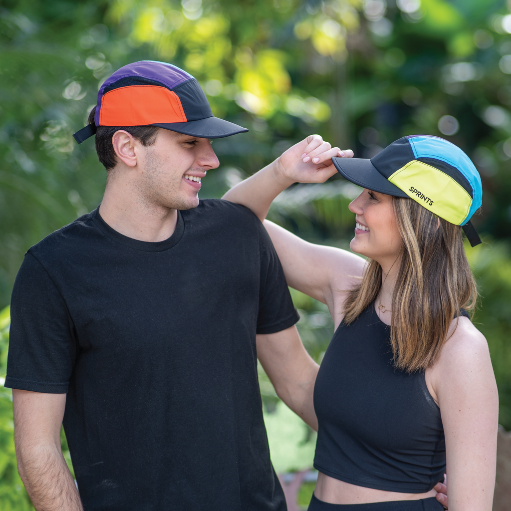 Girl and guy wearing color block 5 Panel hat with colors black, yellow, blue, purple and orange.